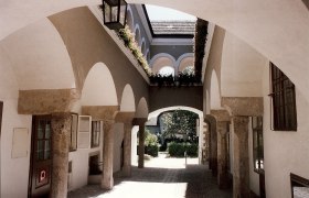 Arkadenhof im Hafnerhaus, © Karanitsch Ein Arkadenhof mit Steinbögen und Blumen im Hafnerhaus.