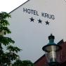 Hauptbild, © martina krug Fassade des Hotel Krug mit drei Sternen, Baum und Straßenlaterne.