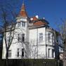 Ferienwohnung Bichler, © Elfriede Bichler Großes weißes Haus mit rotem Dach und Turm, umgeben von kahlen Bäumen.