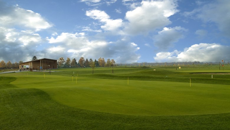Golfclub Guntramsdorf, © C. Steiner Golfplatz mit Clubhaus und bewölktem Himmel.
