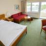 Room, © Badener KurbetriebsgesmbHUlz Hotel room with double bed, red sofa, desk and balcony.