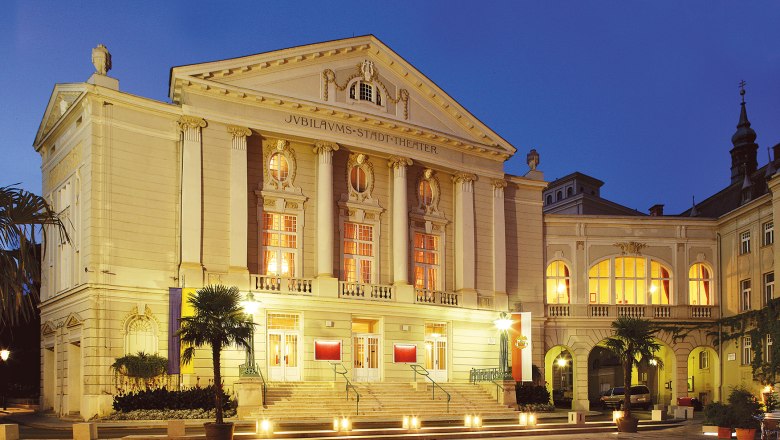 Stadttheater Baden, © Christian Husar Das Stadttheater Baden bei Nacht, beleuchtet mit warmem Licht.