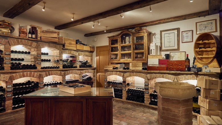 Eigens gekelterter Hauswein, Vinothek, © Niederösterreich Werbung/Andreas Hofer Weinkeller mit Backsteinregalen und Weinflaschen.