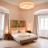 Thallern estate, © Freigut Thallern An elegant bedroom with a double bed, two windows with curtains and stylish lighting.