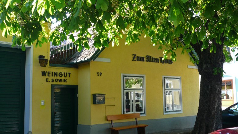 Altes Haus, © Sovik Gelbes Gebäude mit der Aufschrift 'Zum Alten Haus' und 'Weingut E. Sowik', umgeben von grünen Bäumen.