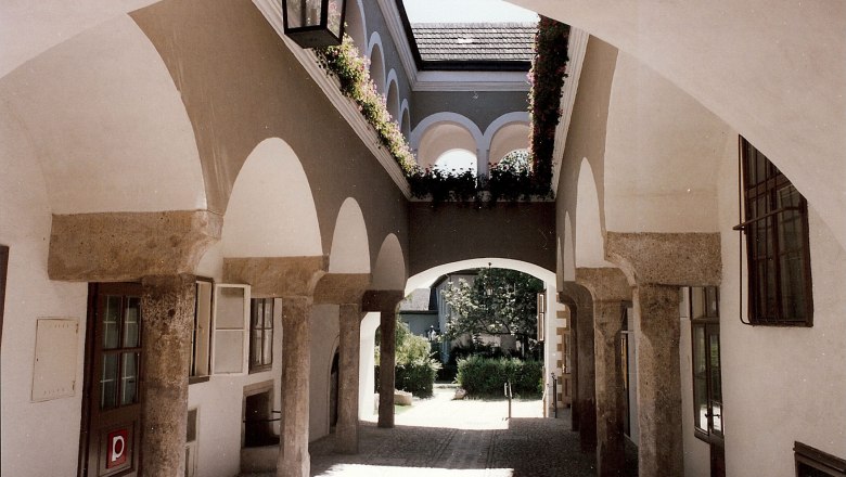 Arkadenhof im Hafnerhaus, © Karanitsch Ein Arkadenhof mit Steinbögen und Blumen im Hafnerhaus.
