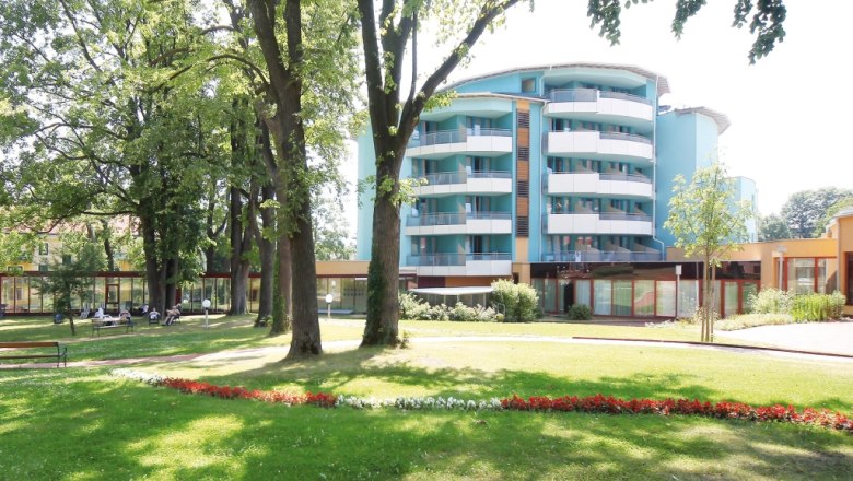 Haus, © Vivea Modernes Gebäude mit Balkonen und Garten im Vordergrund.