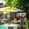 Gastgarten, © Gasthof Smrcka Ein gemütlicher Gastgarten mit Tischen, Stühlen und Sonnenschirmen, umgeben von Bäumen. Menschen sitzen und unterhalten sich.