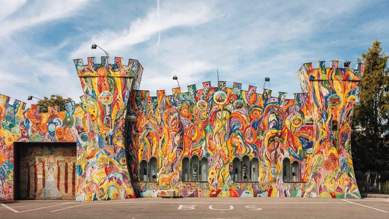 Glass museum "The glass castle", © Kuchlerhaus GmbH Colorfully painted facade of a building in the shape of a castle with towers.