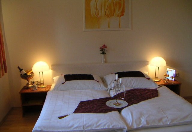 Gemütliches Schlafzimmer mit Doppelbett, Nachttischen und Lampen.