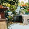 A cozy guest garden with tables and chairs, surrounded by plants and flowers.