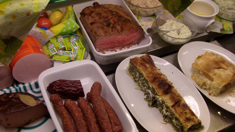 Verschiedene Speisen auf einem Buffet, darunter Fleisch, W&uuml;rste und Strudel.