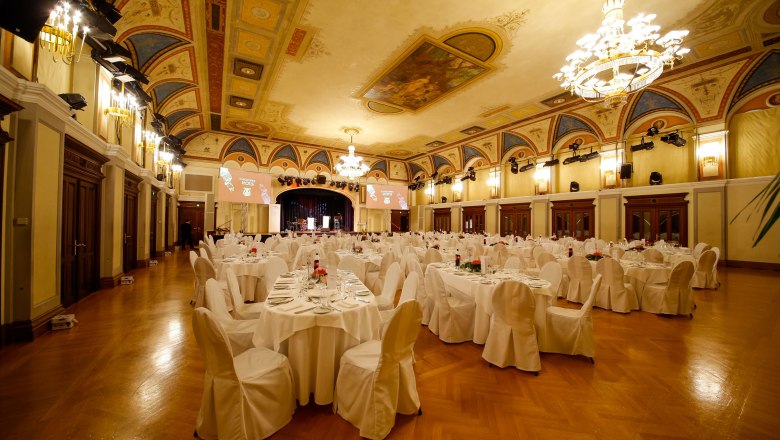 Eleganter Festsaal mit gedeckten Tischen und Kronleuchtern im Congress Center Baden.