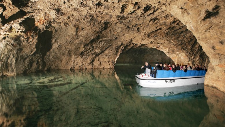 Bootstour in einer unterirdischen H&ouml;hle mit Touristen auf einem kleinen Boot.