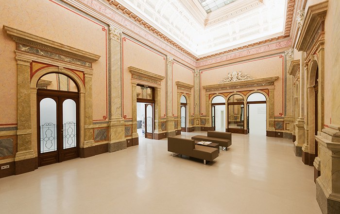 Innenansicht des Arnulf Rainer Museums mit eleganter Architektur und Sitzgelegenheiten.