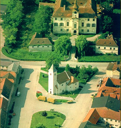 Luftaufnahme eines Dorfes mit Kirche und Schloss in Seibersdorf.