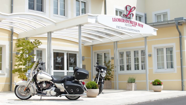 Two motorcycles in front of the entrance to the Leobersdorfer Hof Hotel.