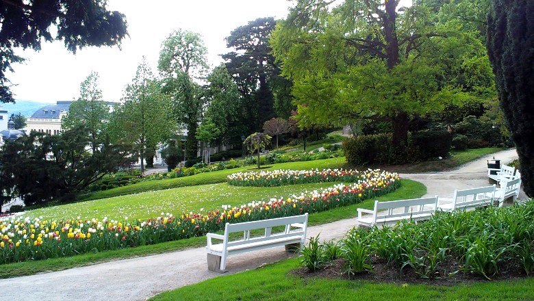 A well-kept park with flowerbeds, benches and trees in Baden bei Wien.