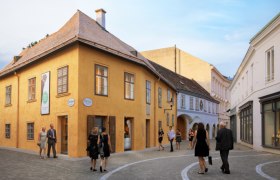 Das Beethovenhaus in Baden mit Passanten auf der Straße.