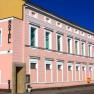 Ein rosa Gebäude mit der Aufschrift 'Hotel' an der Fassade.
