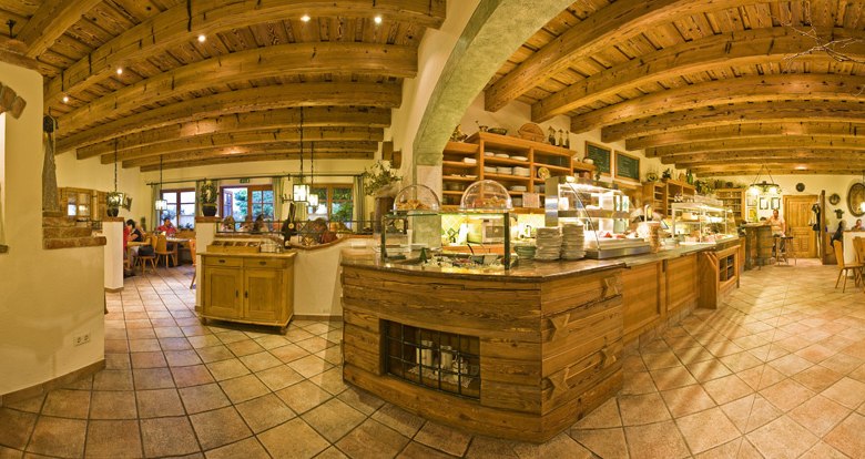 Innenansicht eines gem&uuml;tlichen Heurigenlokals mit Holzbalkendecke und rustikaler Einrichtung.