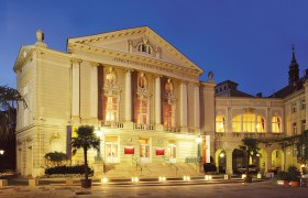 Das Stadttheater Baden bei Nacht, beleuchtet mit warmem Licht.