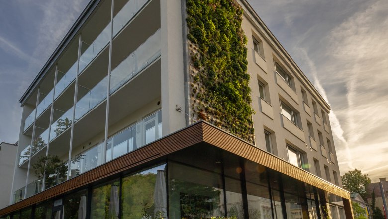 Modern hotel building with vertical garden wall and glass façade.