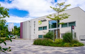 Au&szlig;enansicht des College Garden Hotels mit moderner Architektur und Garten.