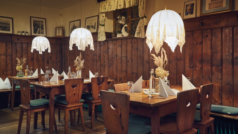 Cozy living room with wooden furniture, table decorations and hanging lamps.