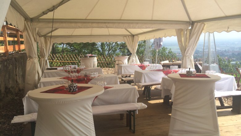 Marquee with set tables and bar tables, decorated for a party.
