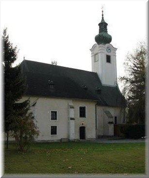 Kirche mit Turm und gr&uuml;nem Dach in Schwadorf.