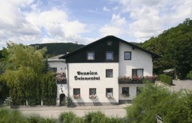 Ein zweist&ouml;ckiges Geb&auml;ude mit der Aufschrift 'Pension Seelenental', umgeben von B&auml;umen und Str&auml;uchern.