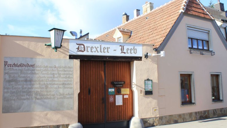 Traditionelles Gebäude mit Schild 'Drexler-Leeb' und Holztor.