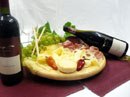Weinflaschen und Käseplatte mit Trauben und Wurst.