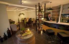 Ein stilvoller Verkostungsraum mit Bar, Tischen und Dekoration.