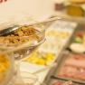 Ein Frühstücksbüffet mit Müsli, Aufschnitt und Obst.