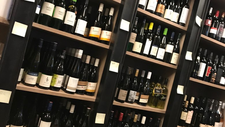 Shelves with various wine bottles in a store.