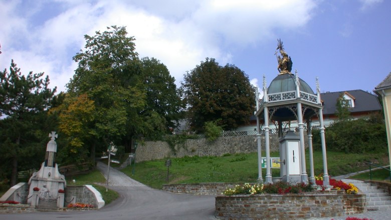 Wallfahrtskirche St. Corona am Schöpfl mit Statue und Pavillon.