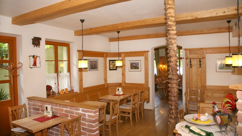 Gemütliche Gaststube mit Holzmöbeln und Dekorationen.