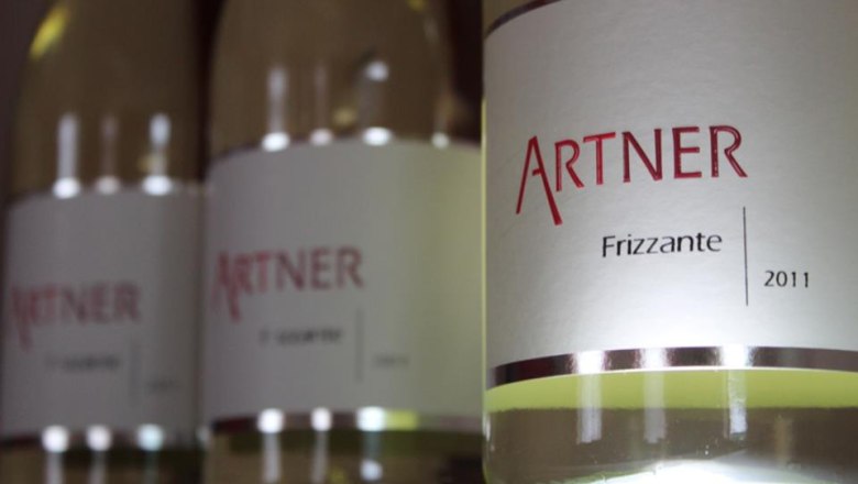 Nahaufnahme von Weinflaschen mit dem Etikett 'Artner Frizzante 2011'.