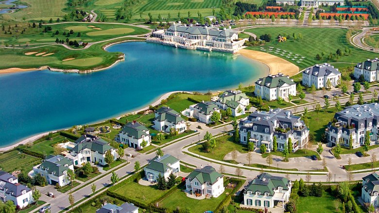 Luftaufnahme von Oberwaltersdorf mit einem See, umgeben von Villen und einem Golfplatz.