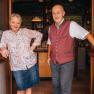 A man and a woman stand smiling in the doorway of a pub.